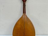 a close up of a mandolin sitting on a white surface