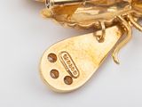 a close up of a gold brooch with a butterfly on it