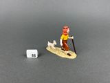 figurine miniature représentant un homme sur une planche de surf avec un chien