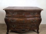 une vieille commode en bois avec des sculptures ornementales sur les tiroirs