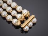 a close up of a necklace with pearls on a black surface