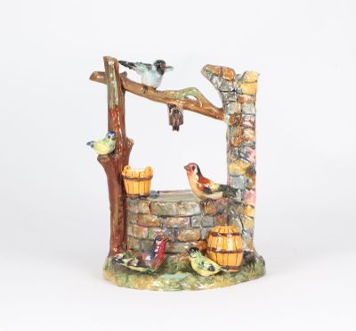 a figurine of a well with birds on it