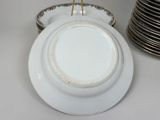a white plate with a gold rim sitting on a table