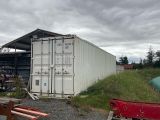 a white shipping container sitting in the middle of a field