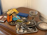a wooden table with a tray of silverware and a tray of utensils