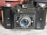an old camera sitting on a table next to a wallet