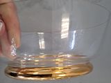 a person holding a glass bowl in front of a set of wine glasses