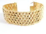 a close up of a gold bracelet on a white background