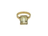 a close up of a gold ring with an emerald stone