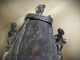 a statue of a man and a woman on top of a bell