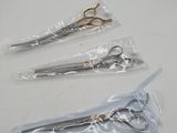 three pairs of scissors are wrapped in plastic on a white surface