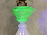 a green glass lamp that is sitting on a glass table
