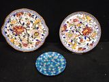 two plates with floral designs are sitting next to each other
