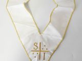 a white stole with a cross and a gold cross on it
