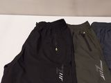 three pairs of men ' s running shorts sitting on a white surface