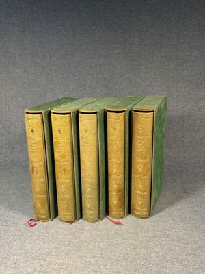 four green books are stacked on top of each other on a gray surface