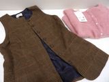 a brown vest and a pink shirt on a white table