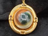 une image représentant un pendentif plaqué or orné d'une horloge