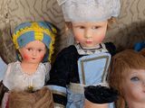 a lot of dolls that are sitting together on a couch