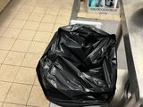 a black bag that is sitting on a toilet in a kitchen