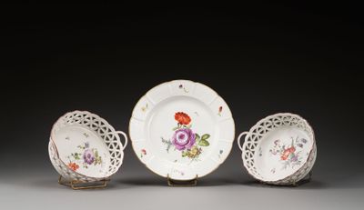 trois assiettes et un bol décorés de fleurs, posés sur une table