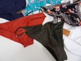 several women ' s swimsuits are laid out on a bed