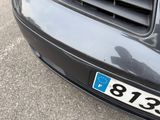 a black car with a blue number plate on the front of it