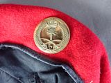 a red hat with a gold button on it
