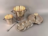 three silver plated cups and a silver plate with a spoon on a table