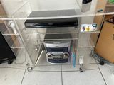 a clear shelf with a dvd player and other electronics