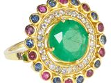 un gros plan d'une bague ornée d'une pierre verte entourée de pierres multicolores