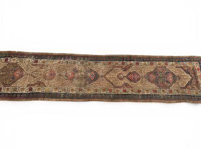 un vieux tapis orné d'un long motif sur fond blanc