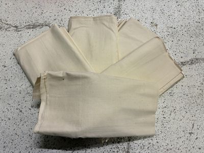 quatre paires de pantalons blancs posées par terre