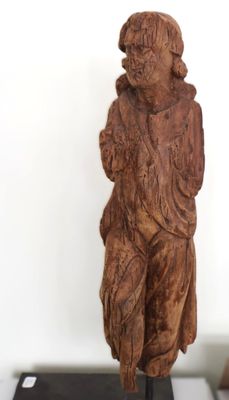 une statue en bois représentant un homme tenant un chien, posée sur un socle