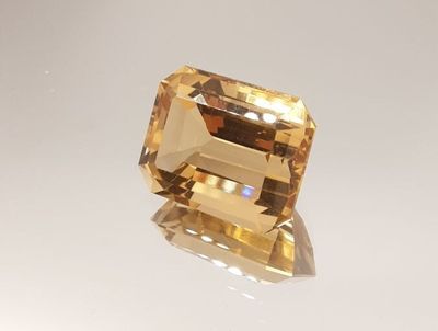 a yellow sapphire stone sitting on top of a white surface