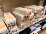 many boxes on the shelves of a store with price tags on them