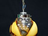 une lampe suspendue à une chaîne sur un fond noir