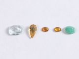a group of five different colored stones on a white surface
