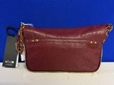 a red purse with a chain around it on a table