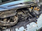 the engine of a car with its hood open on the side of the road