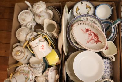 une boîte remplie d'assiettes et de tasses posée par terre