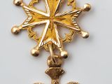 gros plan d'une croix en or sur une surface blanche