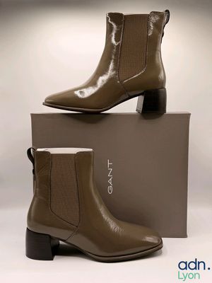 un gros plan sur une paire de bottines marron posées sur une boîte