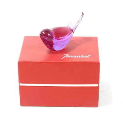 un petit oiseau en verre posé sur une boîte rouge