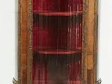 an antique wooden display cabinet with glass doors and a red glass door