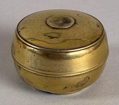a small gold box sitting on a white surface