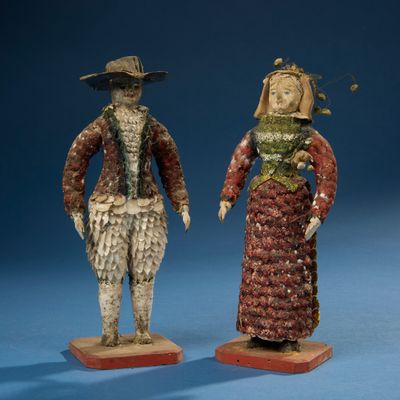 deux figurines représentant un homme et une femme vêtus de costumes d'époque