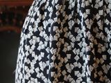 a woman wearing a black and white dress with a pattern on it