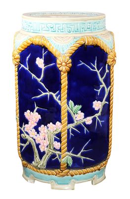 un vase bleu avec des fleurs sur un fond blanc