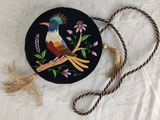 a black purse with a bird on it on a table